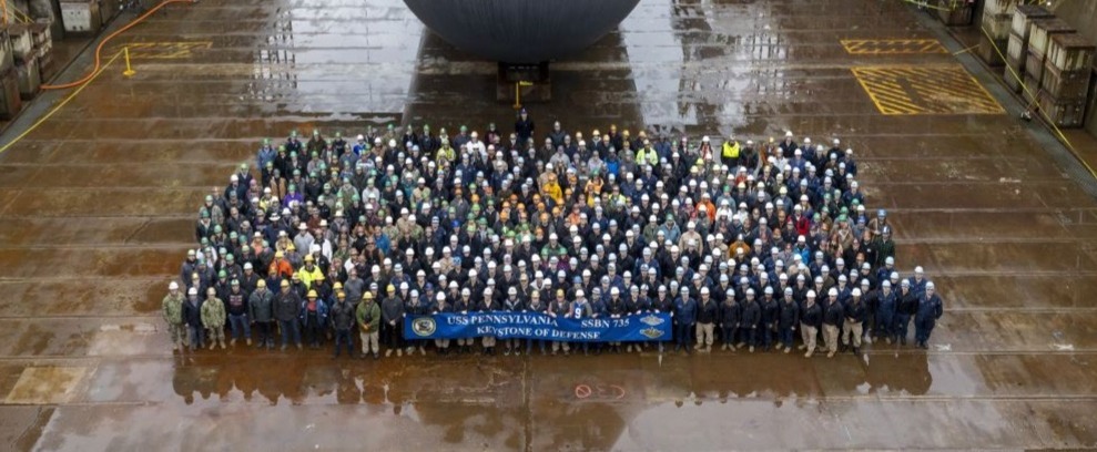 Bremerton, Wash. (Dec. 13, 2024) – Crewmembers assigned to the ballistic missile submarine USS Pennsylvania (SSBN 735) pose for a photo while the ship is in dry dock at Puget Sound Naval Shipyard and Intermediate Maintenance Facility. Pennsylvania won the 2024 Retention Excellence Award and Best-In-Class distinction for Pacific Fleet SSBNs. Commander, Submarine Group (SUBGRU) 9 exercises administrative and operational control authority for assigned submarine commands and units in the Pacific Northwest providing oversight for shipboard training, personnel, supply and material readiness of SSBNs and their crews. SUBGRU-9 is also responsible for nuclear submarines undergoing conversion or overhaul at Puget Sound Naval Shipyard in Bremerton, Washington. SUBGRU-9’s subordinate commands include Submarine Readiness Squadron 31, Submarine Squadrons 17 and 19, eight SSBNs, two SSGNs, and four SSNs homeported in the Pacific Northwest. (U.S. Navy Photo by Wendy Hallmark)