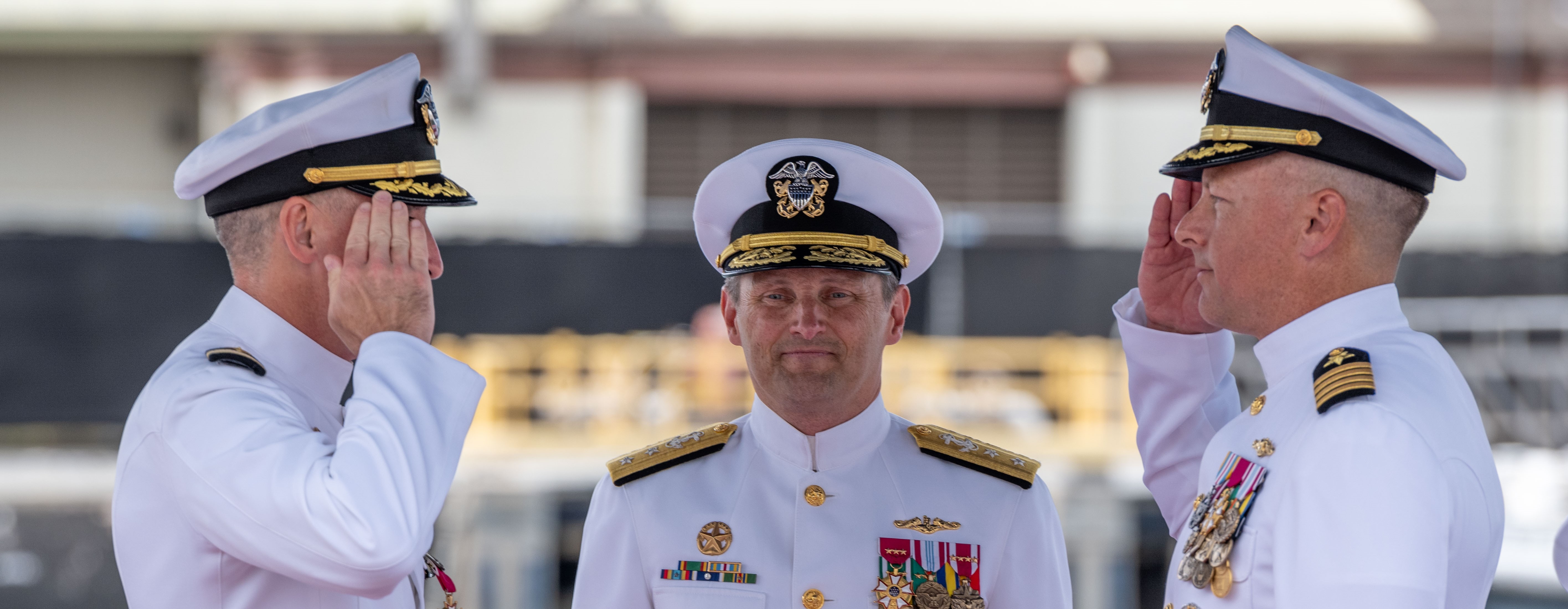 JOINT BASE PEARL HARBOR-HICKAM, Hawaii (July 25, 2025) - Capt. Jeff Fassbender, right, salutes Capt. Corey Poorman, left, as Rear Adm. Chris Cavanaugh, commander, Submarine Force, U.S. Pacific Fleet, center, observes during the Commander, Submarine Squadron 7 change of command ceremony aboard the Los Angeles-class fast-attack submarine USS Columbia (SSN 771), July 25, 2025. During the ceremony, Fassbender, from St. Marys, Kansas, relieved Poorman, from Severna Park, Maryland, as CSS 7 commodore. (U.S. Navy photo by Mass Communication Specialist 1st Class Scott Barnes)
